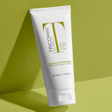 Tricomin conditioner tube on a green background