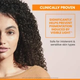 Woman with curly hair, clinically proven to help prevent visible-light pigmentation text
