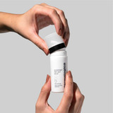 Hands removing the cap from PowerBright Dark Spot Serum bottle