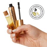 Hand holding the mascara and wand with castor oil vial