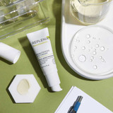 Brightening Eye Cream tube on a green surface with texture swatch
