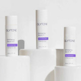 Three Glytone Exfoliating Serum bottles on white blocks