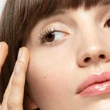 Woman tapping eye gel beneath her eye