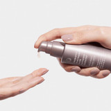 Hand pumping booster serum into an open palm