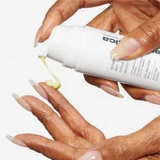 Hand pumping pale yellow Dynamic Skin Retinol Serum onto fingertips