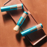 Three brush-on sunscreen applicators on a copper tray
