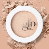 Close-up of the Skin Glow Powder Highlighter compact on crushed powder