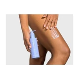 Woman applying lotion to her leg