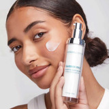 Woman holding the moisturizer with cream on her cheek