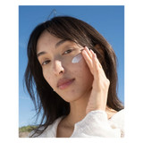 Woman applying moisturizer to her cheek