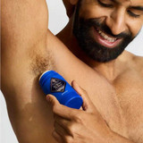 Man applying the deodorant stick to his underarm