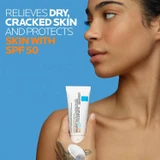 Woman holding the Cicaplast Balm tube at her shoulder