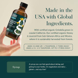 Hand holding the syrup bottle, made in the USA with global ingredients graphic with dosage by age