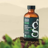 Gaia Herbs Black Elderberry Syrup bottle on soil with plants