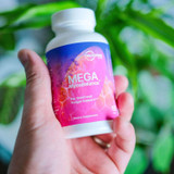 Hand holding the Mega MycoBalance bottle outdoors