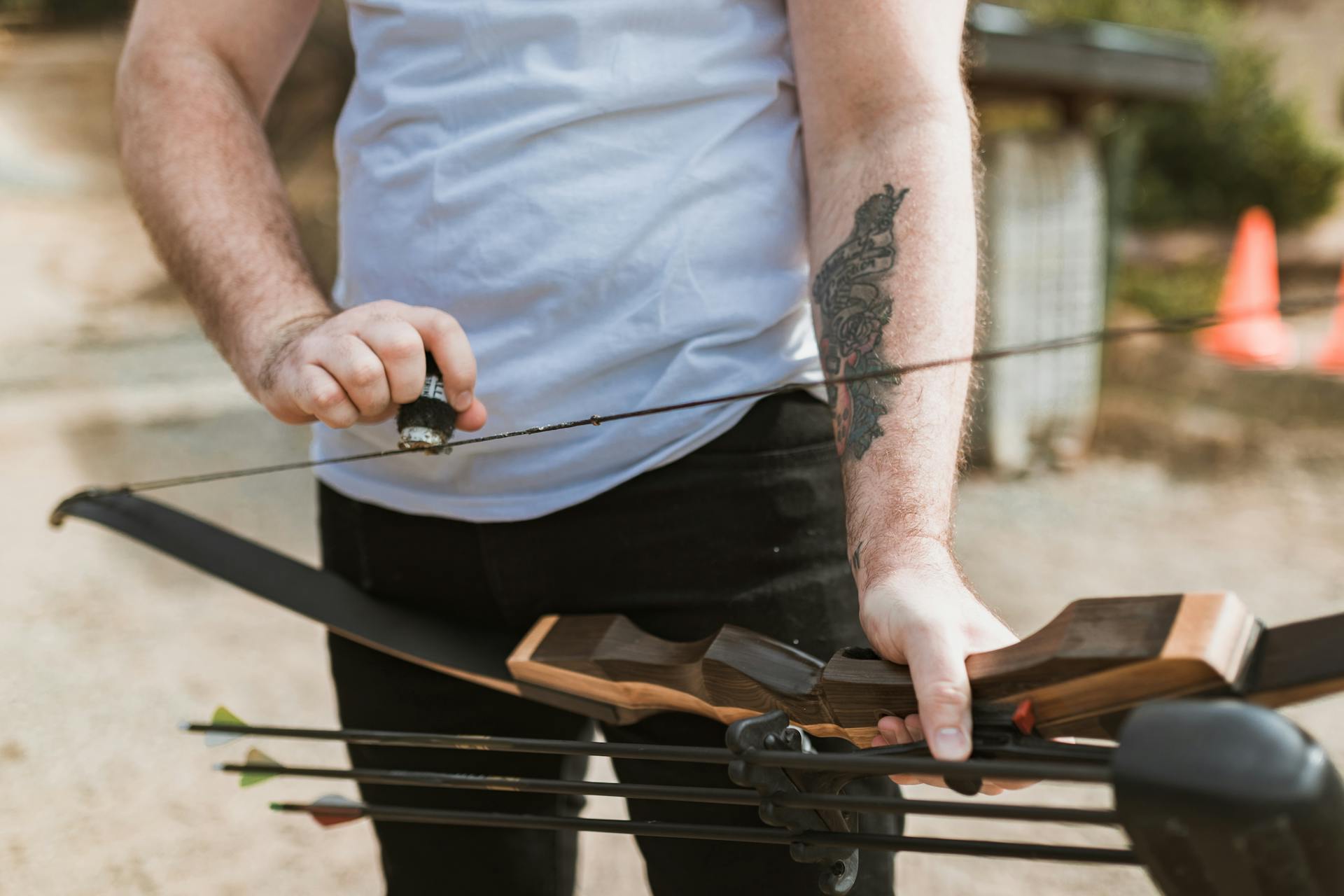Archer applying wax to a bow string