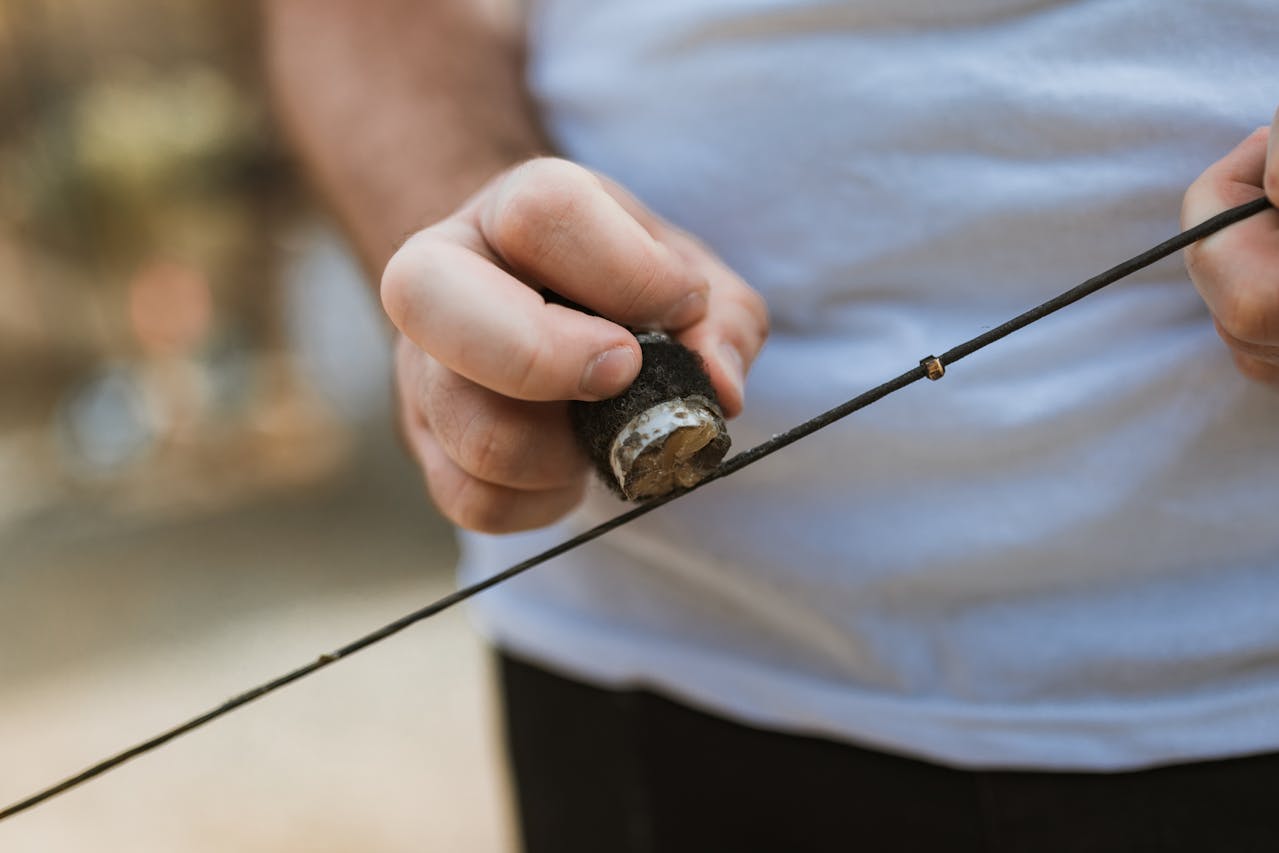 Archer waxing a bow string