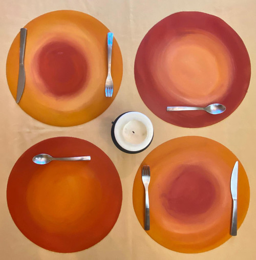 Cosmic Dots - Sunny Pop Arts, Set of 4 Carole Shiber Designs, colorful dinner plates with abstract orange and red swirl patterns, each plate paired with metallic cutlery and a white candle in the center.