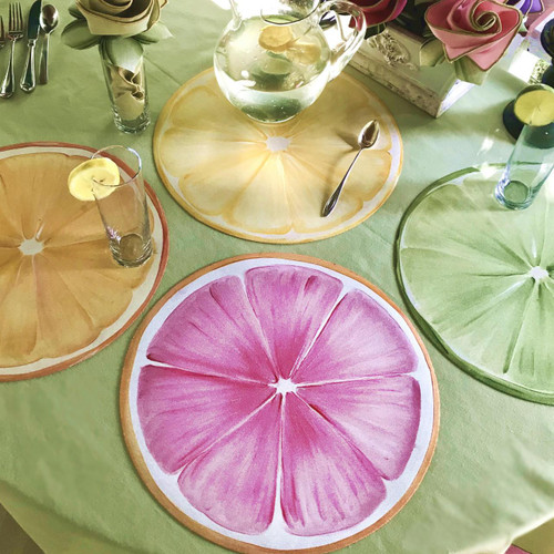 SALE! Artisanal Citrus Slice Placemats by Carole Shiber Designs, colorful round placemats resembling citrus fruit slices on a festive table setting.