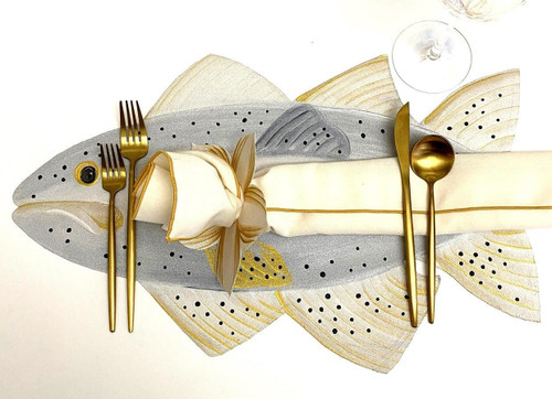 Sea Trout, decorative table setting with a fish-shaped placemat and gold-toned cutlery. Sea Trout, decorative table setting with a fish-shaped placemat and gold-toned cutlery.