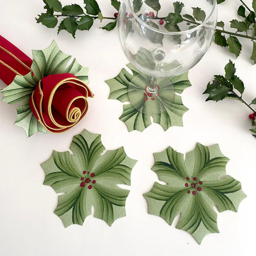 Hand-Painted Hollyberry Rings, Mint Carole Shiber Designs, Christmas-themed fabric Hollyberry coasters with green and red accents surrounding a wine glass on a white surface.
