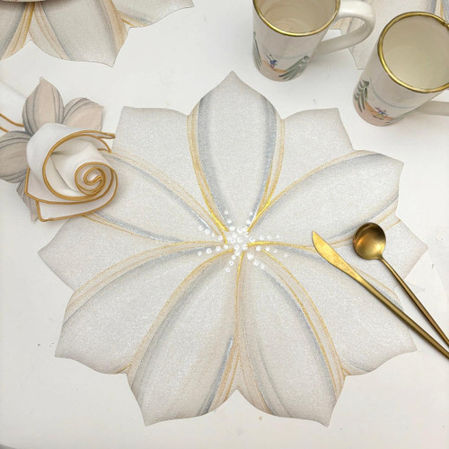 White Poinsettia with Gold & Silver Carole Shiber Designs, holiday-themed table centerpiece with glittery white poinsettia flowers accented with gold and silver detailing, paired with matching mugs, a gold spoon, and a gold and silver knife on a white table.