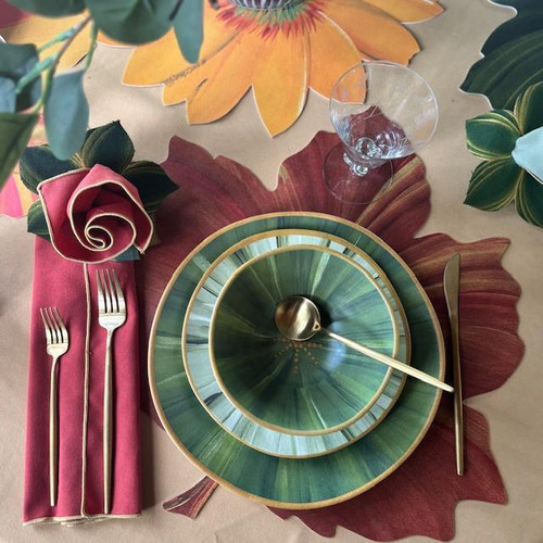 Classic Maple Burgundy, elegant dinnerware set on autumn leaf placemat with glass of water and floral napkin arrangement.