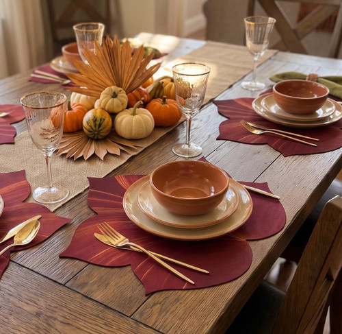 Fountain Leaf Placemat in Burgundy by Carole Shiber, autumn-themed table setting with burgundy leaf-shaped placemats on a wooden table.