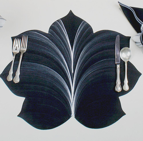 7 Point Leaf - Black/White Carole Shiber Designs, decorative black and white leaf-shaped placemat on a table setting with silverware.