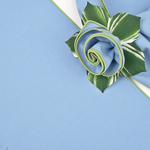 Add a Round Light Blue with HoneyDew Trim Napkin Carole Shiber Designs, close-up of a light blue napkin with a honeydew green trim artfully shaped into a rose, with green and white striped leaves.
