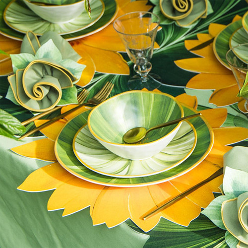 Wild Sunflower Tablescape Carole Shiber Designs, vibrant yellow and green sunflower-themed dinnerware and table setting with matching napkins, gold utensils, and glassware.