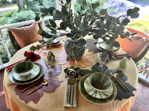Sun on Autumn Leaves, Set of 5 decorative leaf-shaped placemats on a dining table with green and purple tones, arranged under plates and utensils for an elegant fall-themed table setting.
