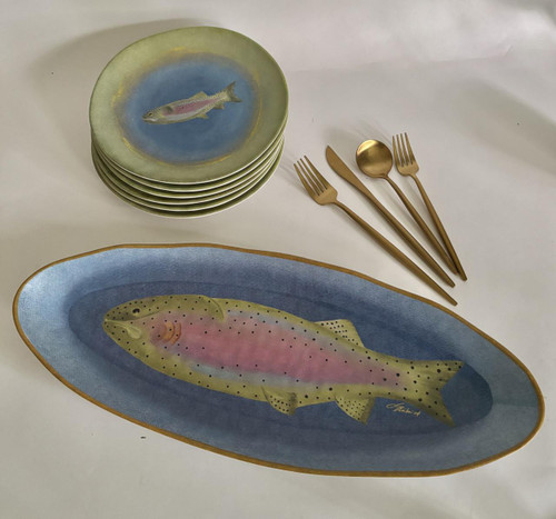 Rainbow Trout 7-Pc. Entertainer's Set, fish-themed dinnerware including a large oval platter and a stack of smaller plates, along with gold-colored cutlery including two forks, a knife, and a spoon, designed for serving and entertaining.
