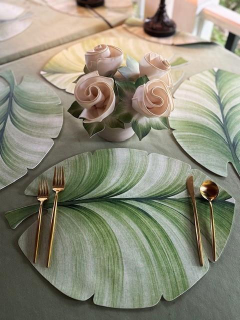 Palm Leaf Place-Settings, Set for 4, decorative tableware with large green palm leaf placemats and a floral centerpiece with roses.