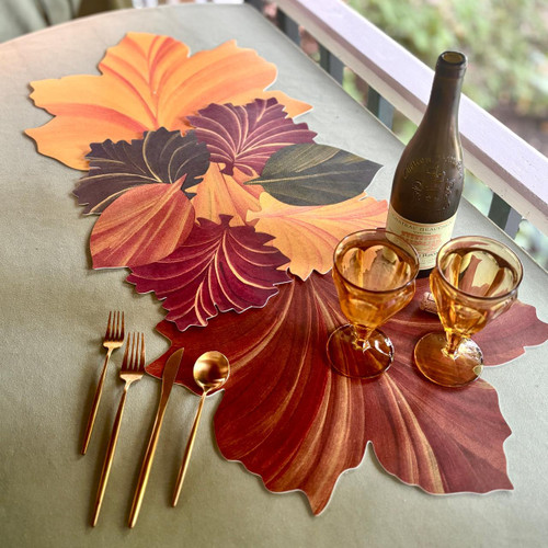 Autumn Leaves 3-Pc. Centerpiece, decorative fall-themed paper leaves in vibrant autumn colors arranged as a centerpiece on a table with tableware and glasses.