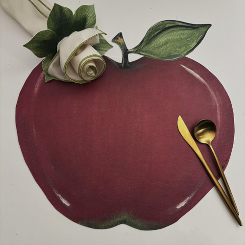 Deep Red Apple Placemat Carole Shiber Designs with green leaf decoration and gold utensils.