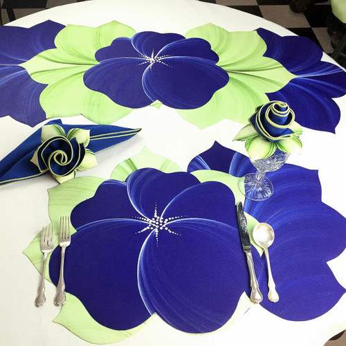 Buttercup Placemat - Dark Blue Carole Shiber Designs, a dark blue flower-shaped placemat with green accents on a white table.