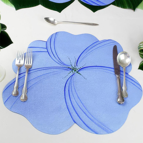 Buttercup Placemat - Light Blue Carole Shiber Designs, decorative floral-shaped placemat in light blue with darker blue accents, set with silverware on a white table with green foliage accents.
