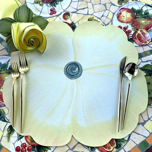 Garden Party Pansies! in Yellow by Carole Shiber, a decorative placemat with a large yellow pansy design, set on a colorful mosaic table with a yellow napkin folded like a rose and gold-colored cutlery.