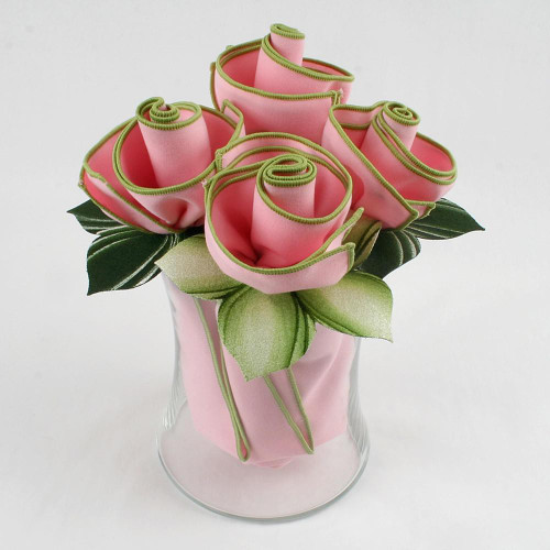 Soft Pink Napkin Bouquet Carole Shiber Designs, a flower arrangement crafted from folded pink napkins with green accents, displayed in a clear glass vase.