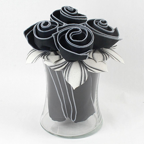 The Lights Out! Napkin Bouquet Carole Shiber Designs, a decorative arrangement of black and white folded napkins resembling roses in a clear glass vase.