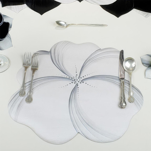 Buttercup Placemat - White/Silver Carole Shiber Designs, elegant floral-shaped placemat with a white and silver design placed on a table setting with silverware and glassware.