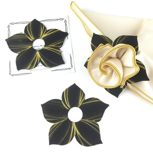 Bouquet Napkin Ring - Black/Gold Carole Shiber Designs, close-up of black fabric napkin ring with gold stripe accents and gold piping, showcasing its floral shape with a central circular hole.