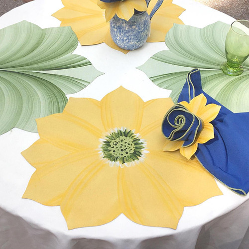 Yellow Daisy Placemat Carole Shiber Designs, decorative yellow floral placemat with green center on a table set for a meal.