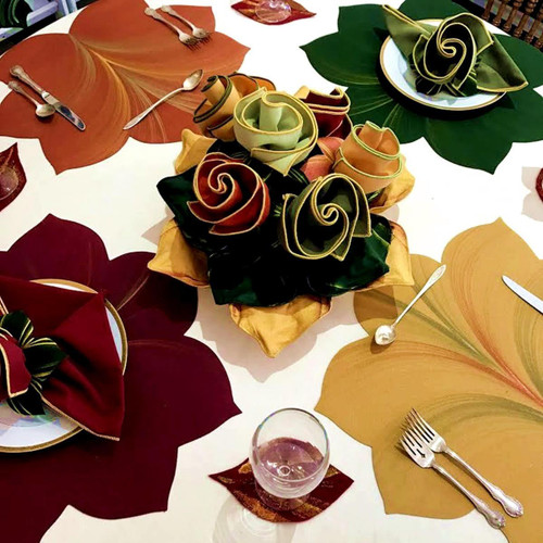 Jeweltone Hand Painted Leaf Placemats - Assorted Carole Shiber Designs, colorful leaf-shaped table placemats and matching napkins arranged for a dining setting.