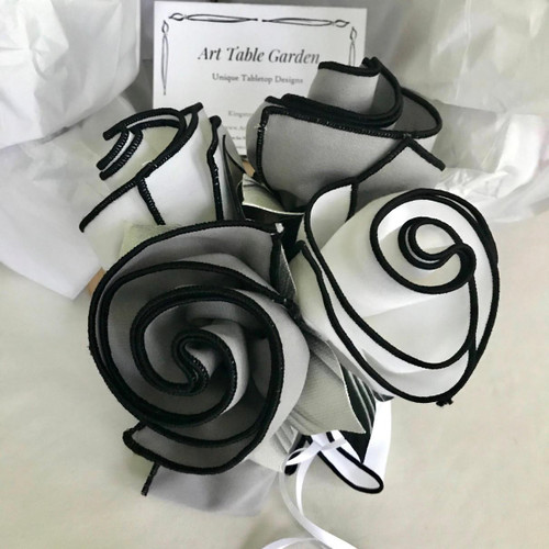 Shades of Grey & White Carole Shiber Designs, a handcrafted fabric flower art piece with grey and white fabric petals accented with black trim.