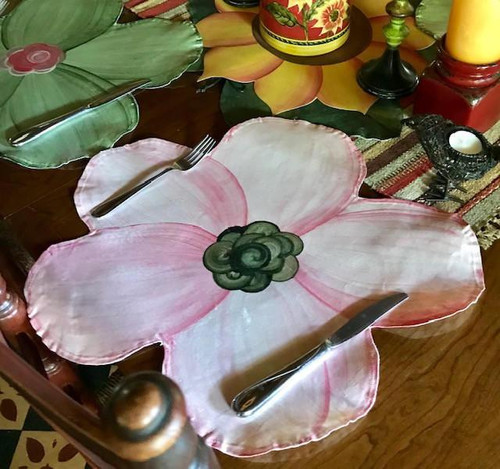 Peony in Pink dinnerware, pink and white floral shaped plate with green center, styled as a flower, on a wooden table setting with cutlery.