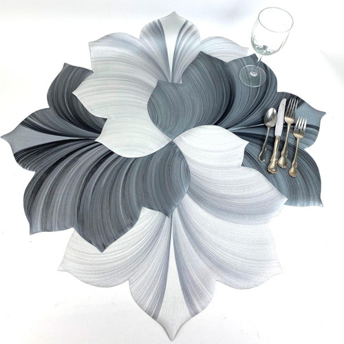 Interlocking Leaf - Grey/Black Carole Shiber Designs, artistic table decor with layered leaf-shaped pieces in grey, black, and white on a white background, with cutlery and a wine glass.