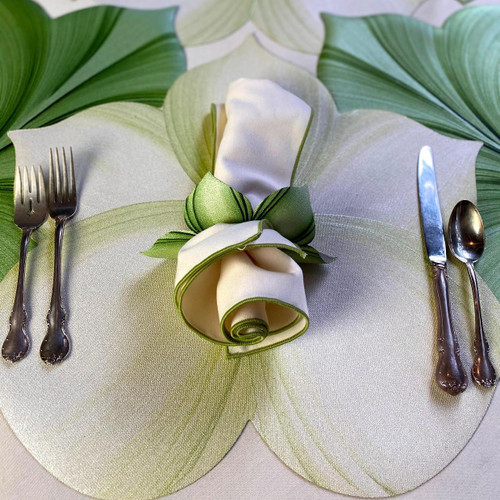 White Lily Placemat Carole Shiber Designs, elegant table setting with cutlery and a decorative napkin flower on a leaf-patterned placemat.