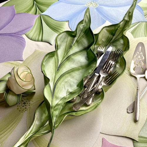 White Wine Basket Duet Carole Shiber Designs, decorative leaf-shaped metal basket with silverware, arranged on a colorful tablecloth with flower and leaf motifs. White Wine Basket Duet Carole Shiber Designs, decorative leaf-shaped metal basket with silverware, arranged on a colorful tablecloth with flower and leaf motifs.